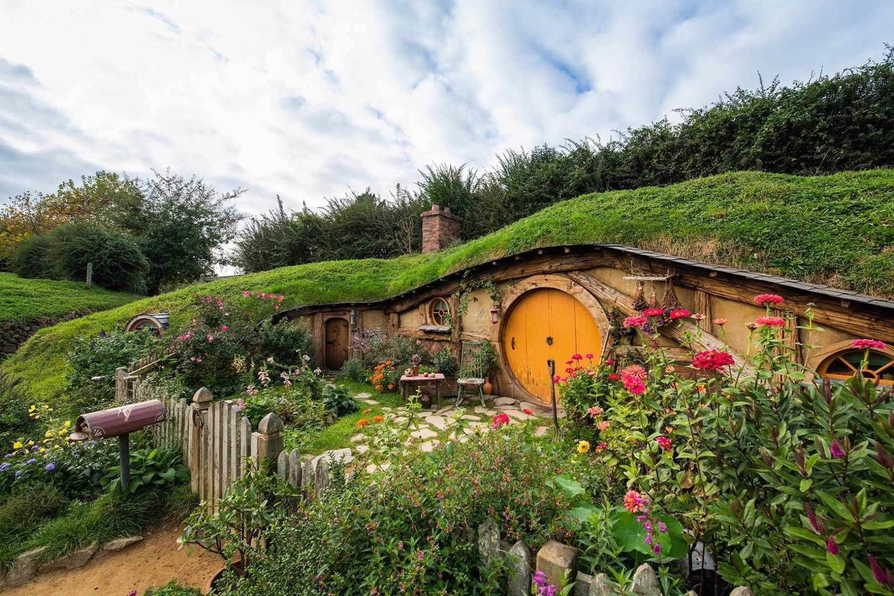 A hobbit hole with a round orange door at Hobbiton